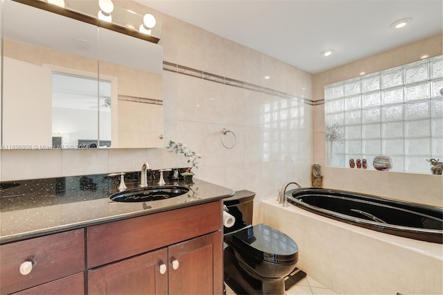 bathroom featuring tile patterned flooring, vanity, a relaxing tiled tub, and tile walls