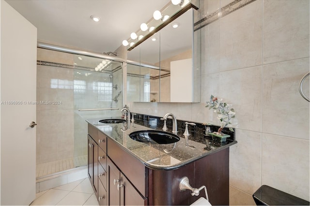 bathroom with tile patterned floors, vanity, tile walls, and walk in shower