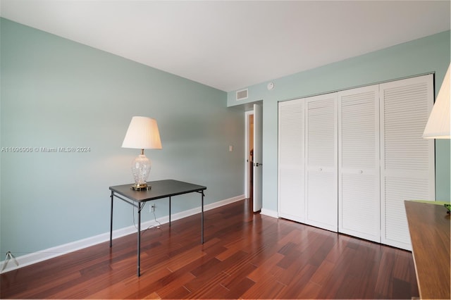 unfurnished bedroom with dark hardwood / wood-style flooring and a closet