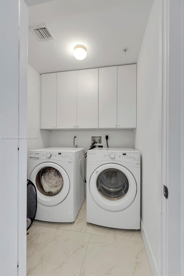 17301 Biscayne Blvd Unit 1404, North Miami, FL 33160 - laundry area with washer and dryer, light marble finish flooring, cabinet space, and baseboards
