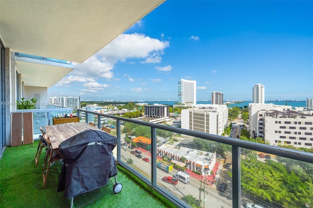 balcony with a water view and area for grilling