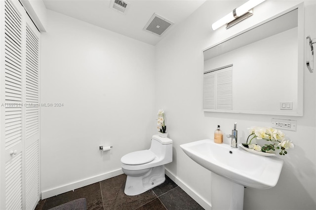 bathroom featuring tile patterned flooring, toilet, and sink