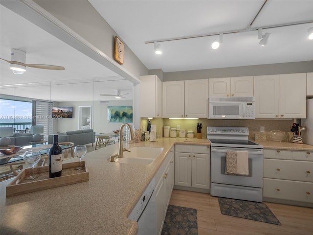 kitchen featuring white cabinetry, sink, tasteful backsplash, white appliances, and light wood-type flooring