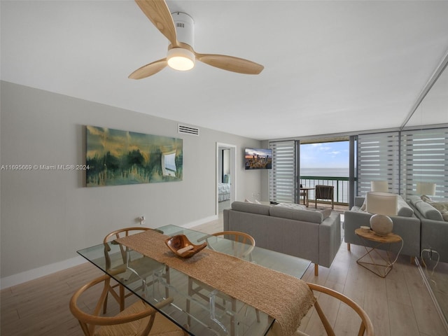 dining space featuring ceiling fan, light hardwood / wood-style floors, and expansive windows