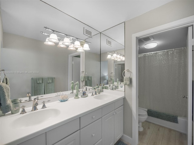 bathroom with toilet, vanity, and hardwood / wood-style flooring