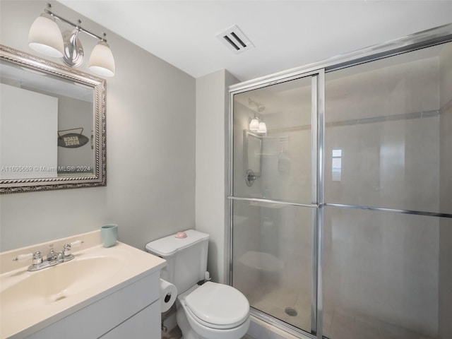 bathroom with vanity, toilet, and a shower with shower door