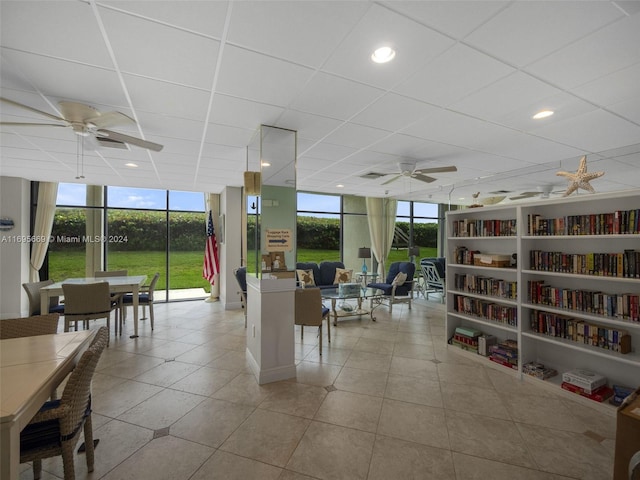 interior space with a paneled ceiling, ceiling fan, and plenty of natural light