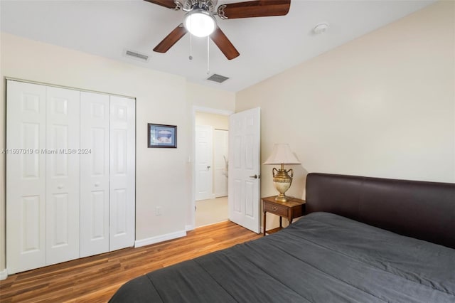 bedroom with hardwood / wood-style floors, ceiling fan, and a closet