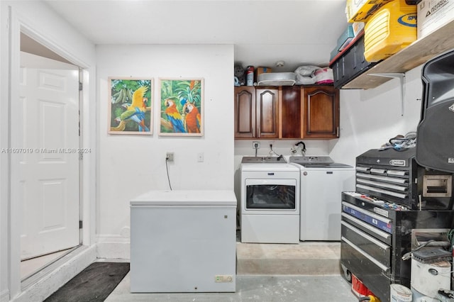 clothes washing area featuring washing machine and dryer and cabinets