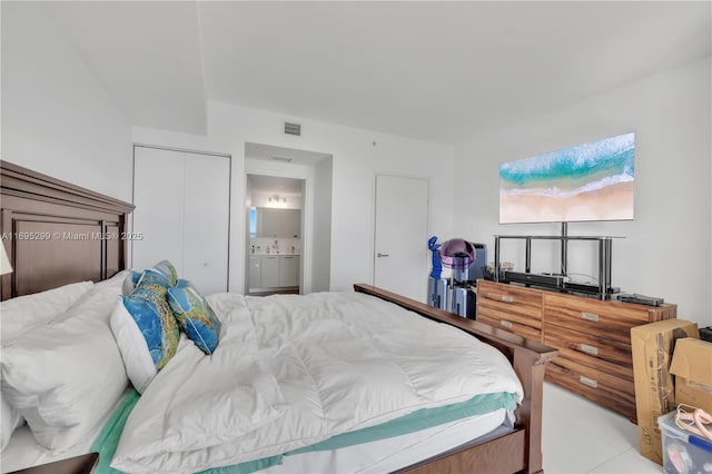 bedroom with connected bathroom and light tile patterned floors