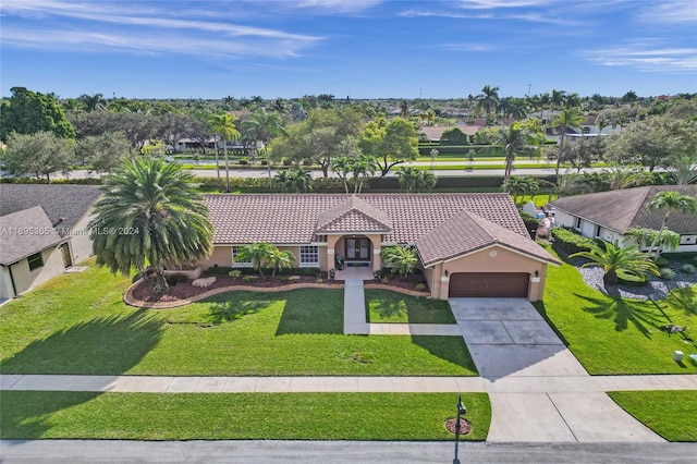 mediterranean / spanish home with a garage and a front lawn