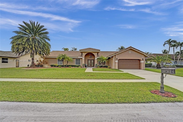 mediterranean / spanish-style house featuring a front yard and a garage