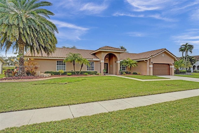 mediterranean / spanish-style home with a front lawn and a garage