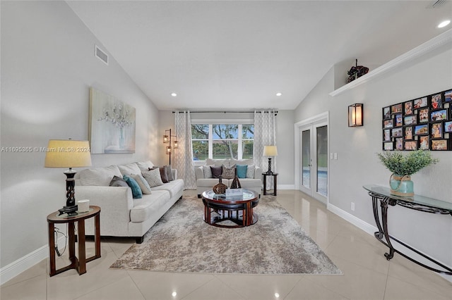 tiled living room featuring french doors and vaulted ceiling