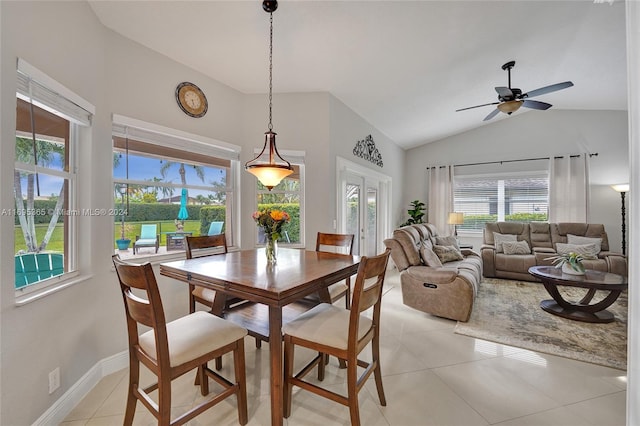 tiled dining area with ceiling fan, a healthy amount of sunlight, and vaulted ceiling