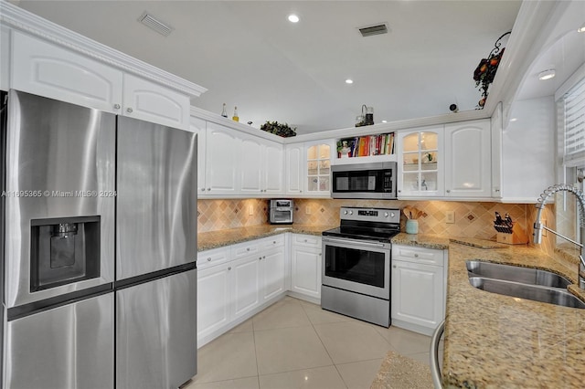 kitchen with light stone counters, white cabinetry, sink, and appliances with stainless steel finishes