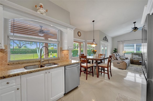 kitchen featuring white cabinets, decorative backsplash, stainless steel dishwasher, and a wealth of natural light