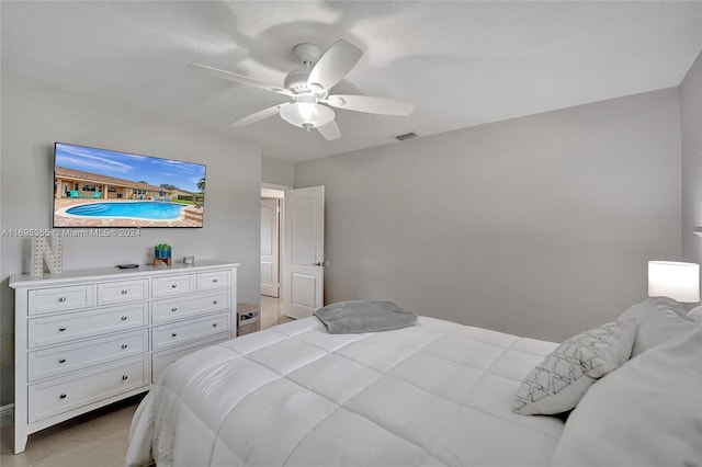 tiled bedroom featuring ceiling fan