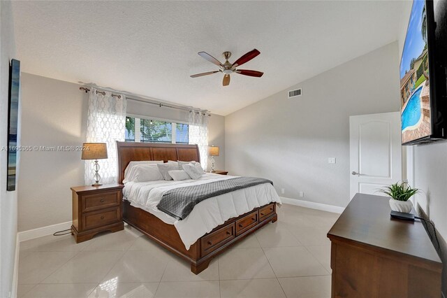 tiled bedroom with a textured ceiling, ceiling fan, and lofted ceiling