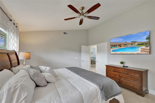 tiled bedroom with ceiling fan and lofted ceiling