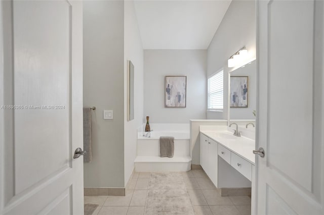 bathroom featuring tile patterned flooring, vanity, and a bath