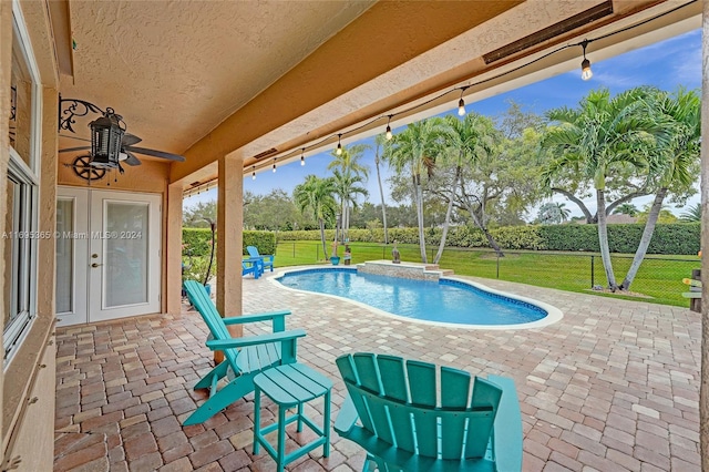 view of swimming pool featuring a lawn, ceiling fan, a patio, and french doors