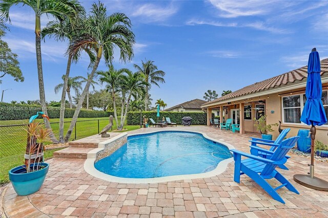 view of pool with a patio area and a yard