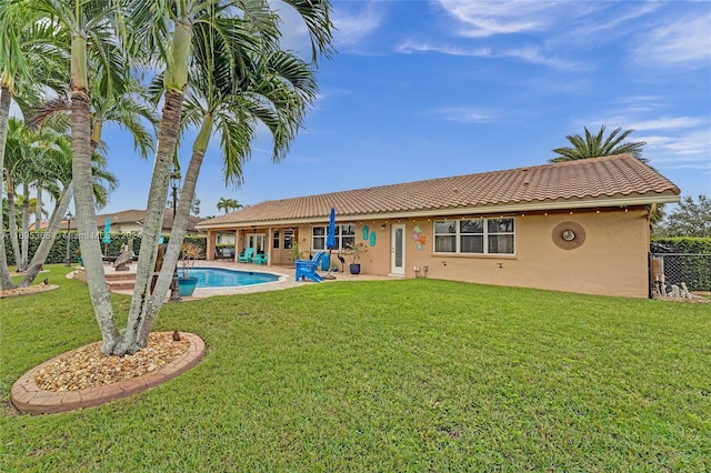 back of property with a lawn and a patio area