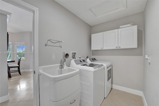 laundry area featuring independent washer and dryer, cabinets, light tile patterned floors, and sink