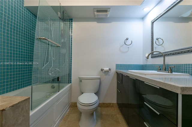 full bathroom featuring toilet, vanity, tile patterned floors, and bath / shower combo with glass door