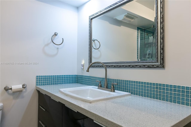 bathroom with decorative backsplash and vanity