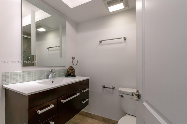 bathroom with vanity, backsplash, and toilet