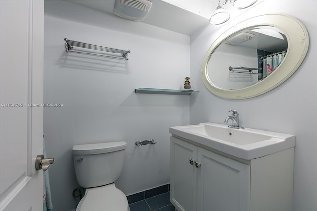 bathroom featuring tile patterned flooring, vanity, and toilet