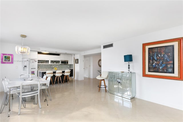 tiled dining room featuring a notable chandelier