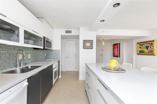 kitchen with white cabinetry, white appliances, sink, and tasteful backsplash