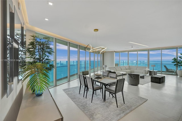 sunroom / solarium featuring a water view and a chandelier