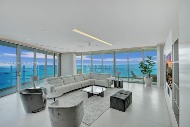 living room featuring floor to ceiling windows, ceiling fan, and a water view