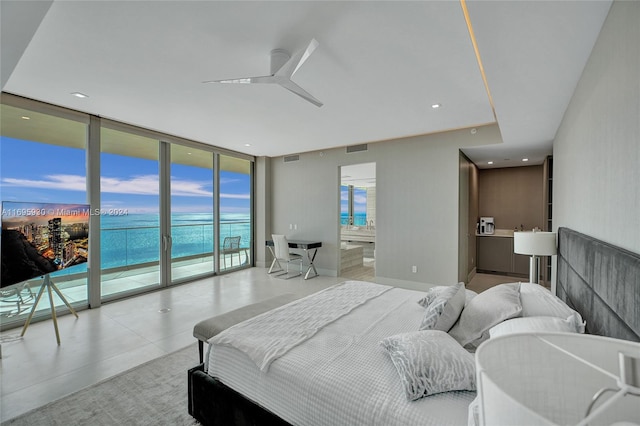 bedroom featuring access to exterior, ceiling fan, ensuite bath, a wall of windows, and a water view