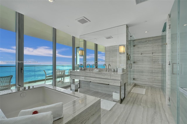 bathroom featuring vanity, plenty of natural light, a water view, and shower with separate bathtub