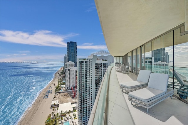 balcony featuring a water view and a beach view