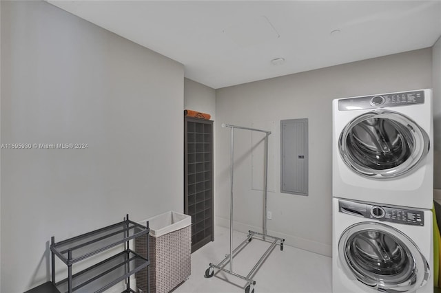 laundry area with electric panel and stacked washer and clothes dryer