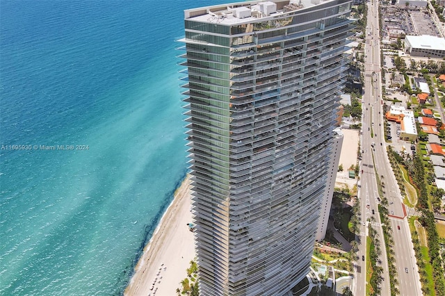 view of building exterior with a water view and a beach view