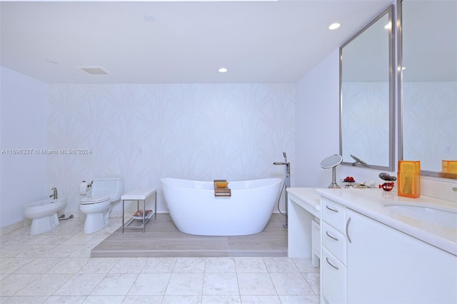 bathroom with vanity, a bathtub, a bidet, and tile patterned flooring