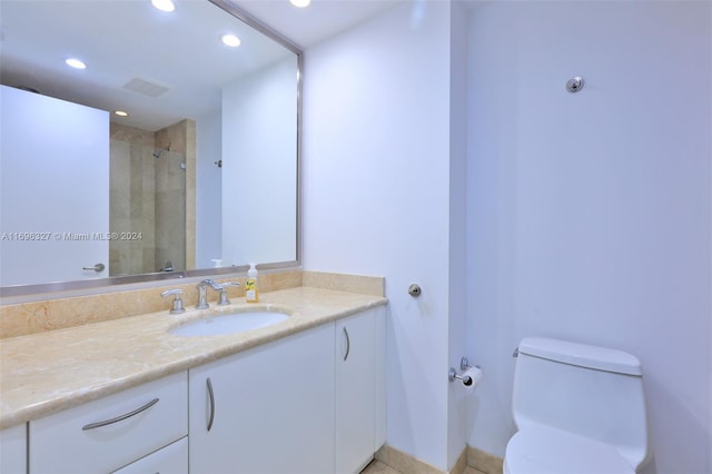 bathroom with walk in shower, vanity, and toilet