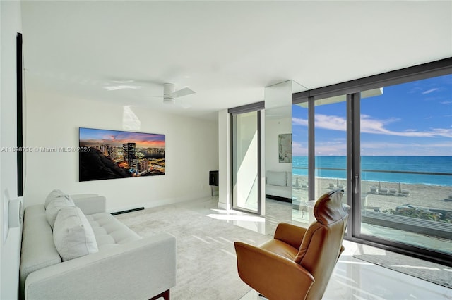 living room with ceiling fan and a wall of windows