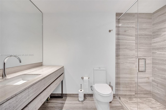 bathroom with vanity, toilet, and a shower with door