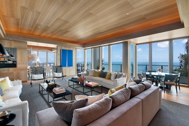 living room featuring a healthy amount of sunlight, hardwood / wood-style floors, a water view, and wood ceiling