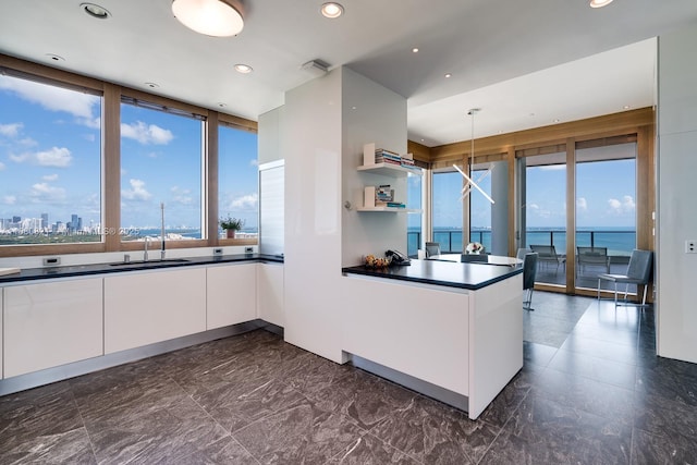2627 S Bayshore Dr Unit 3201, Miami, FL 33133 - kitchen featuring a sink, a peninsula, white cabinets, dark countertops, and modern cabinets