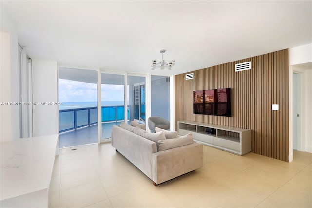 living room with wood walls, ceiling fan, and floor to ceiling windows