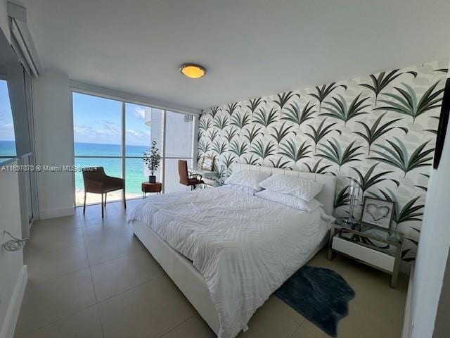 bedroom featuring access to exterior and a water view